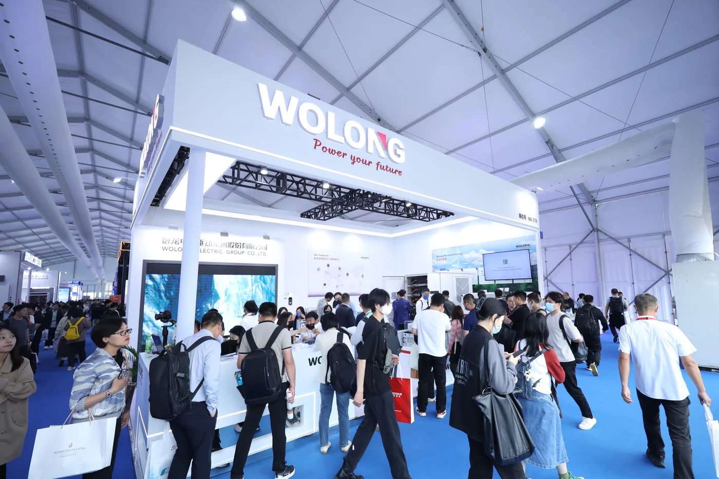 Visitors meeting the Wolong team at a busy exhibition booth