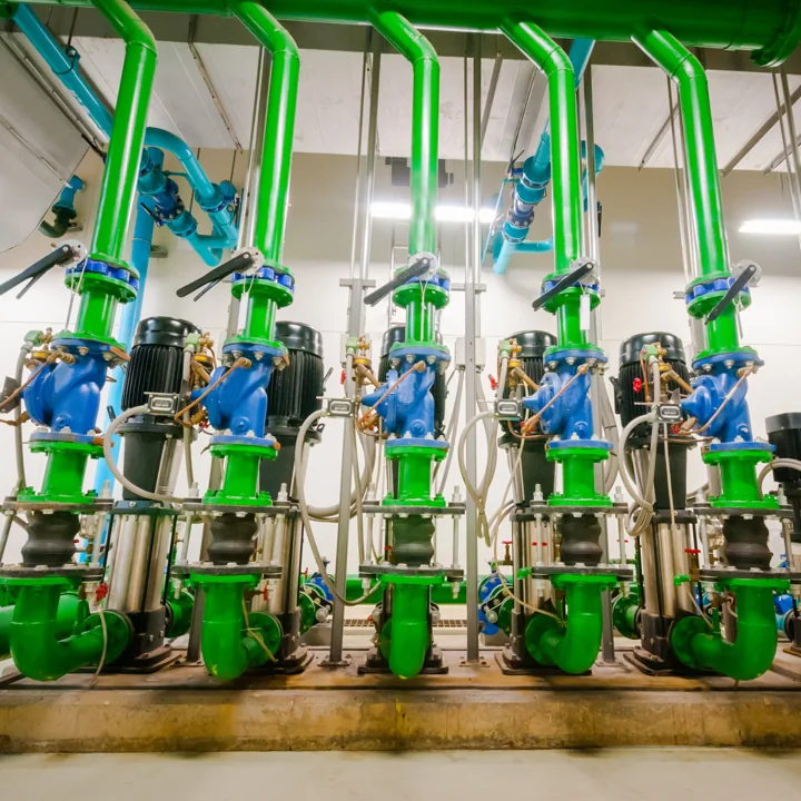 Bank of vertical pumps with green pipework